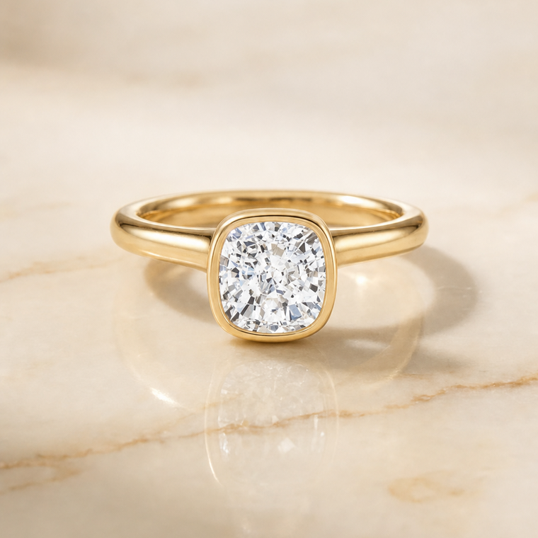 The Duran Simple Bezel Solitaire Cushion Cut Engagement Ring Setting in 18K Yellow Gold