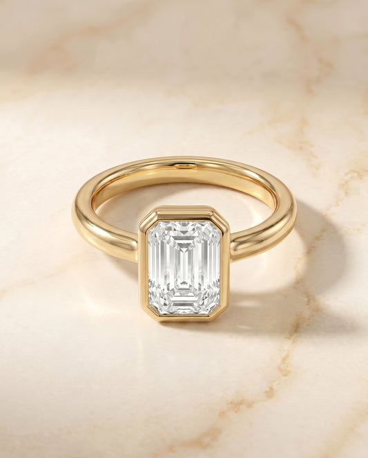 The Agnes Bezel Solitaire Engagement Ring Setting for Emerald Cut Diamonds in 18K Yellow Gold | RockHer