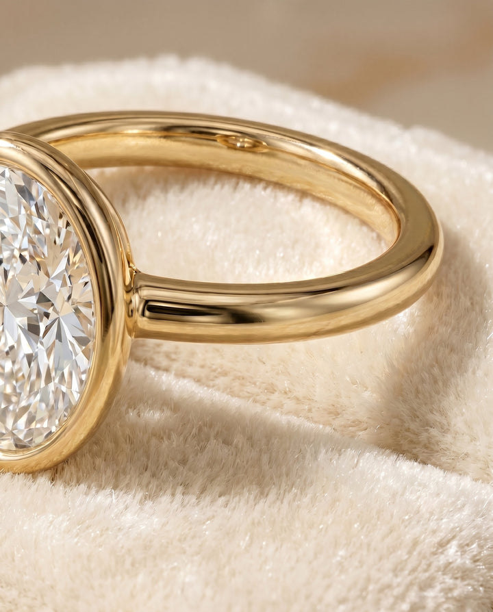 Agnes Select Bezel Solitaire In Oval Lab Diamond Engagement Ring in 18K Yellow Gold, detail view | RockHer