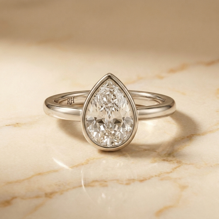 The Agnes Select bezel solitaire briolette engagement ring in 18k white gold — front view — RockHer