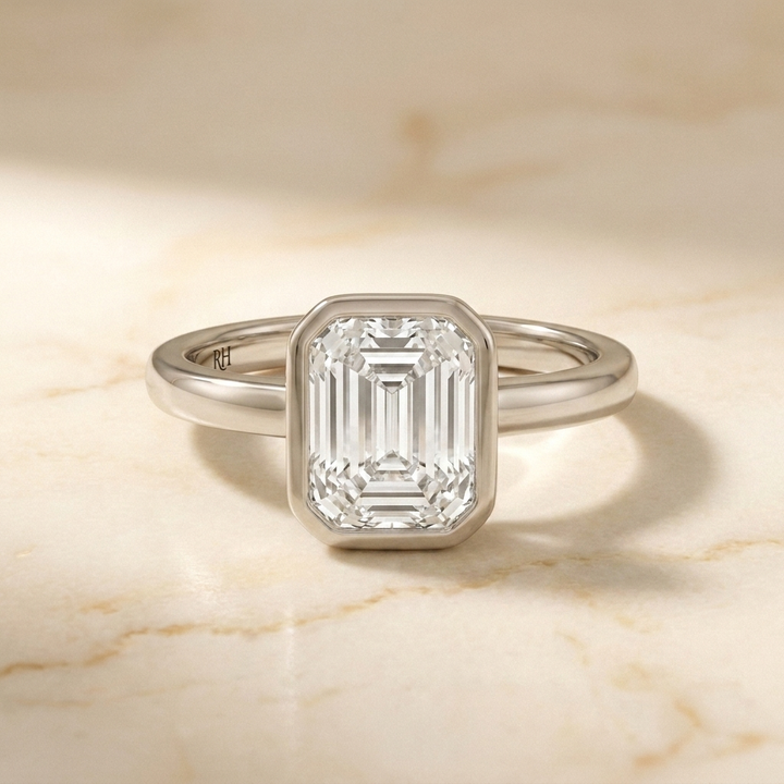 The Agnes Select bezel solitaire emerald cut engagement ring in platinum — front view — RockHer