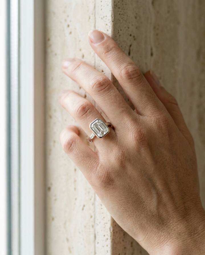 The Agnes Select bezel solitaire emerald cut engagement ring in platinum — on hand — RockHer
