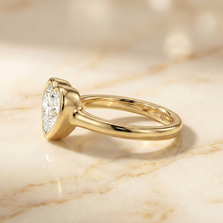 The Agnes Select bezel solitaire heart engagement ring in 18k yellow gold — side profile — RockHer