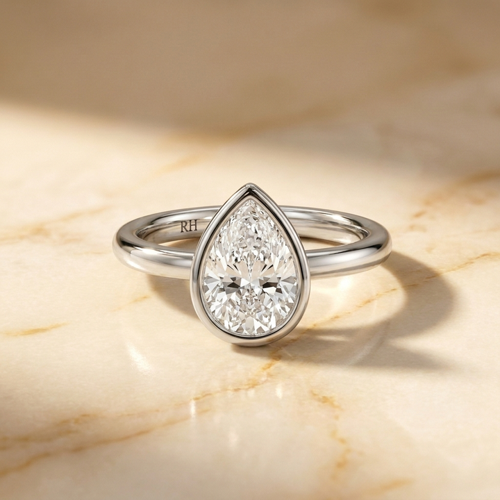 The Agnes Select bezel solitaire pear engagement ring in platinum — front view — RockHer