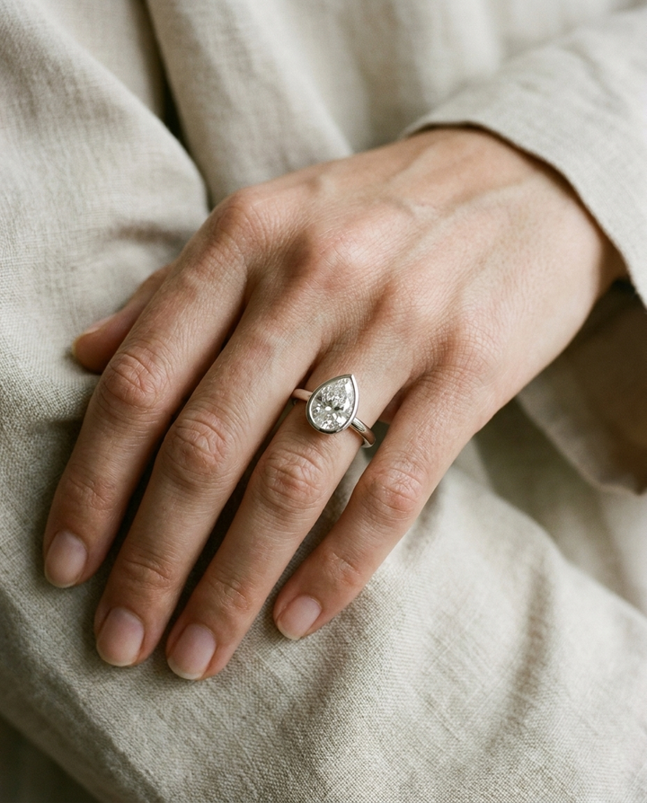 The Agnes Select bezel solitaire pear engagement ring in 18k white gold — on hand — RockHer