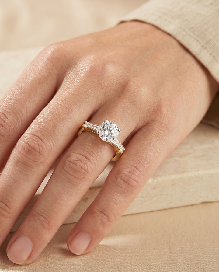 Round Brilliant, Baguette and Round Side Stone, in 18K Yellow Gold – lifestyle shot | RockHer