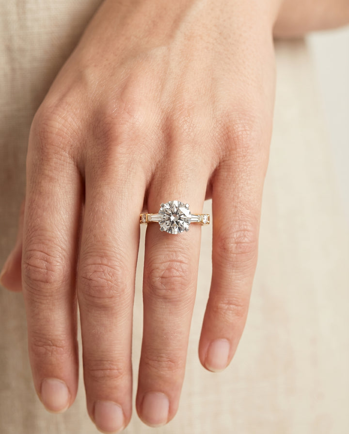 Round Brilliant, Baguette and Round Side Stone, in 18K Yellow Gold – lifestyle shot | RockHer