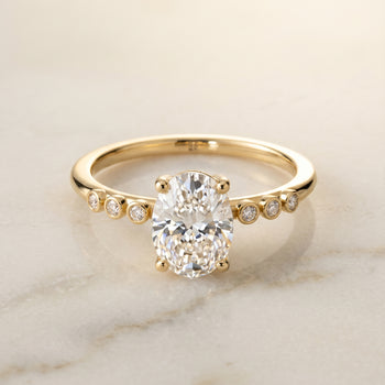 The Peggy Bezel Accent Solitaire Oval Engagement Ring Setting in 18K Yellow Gold