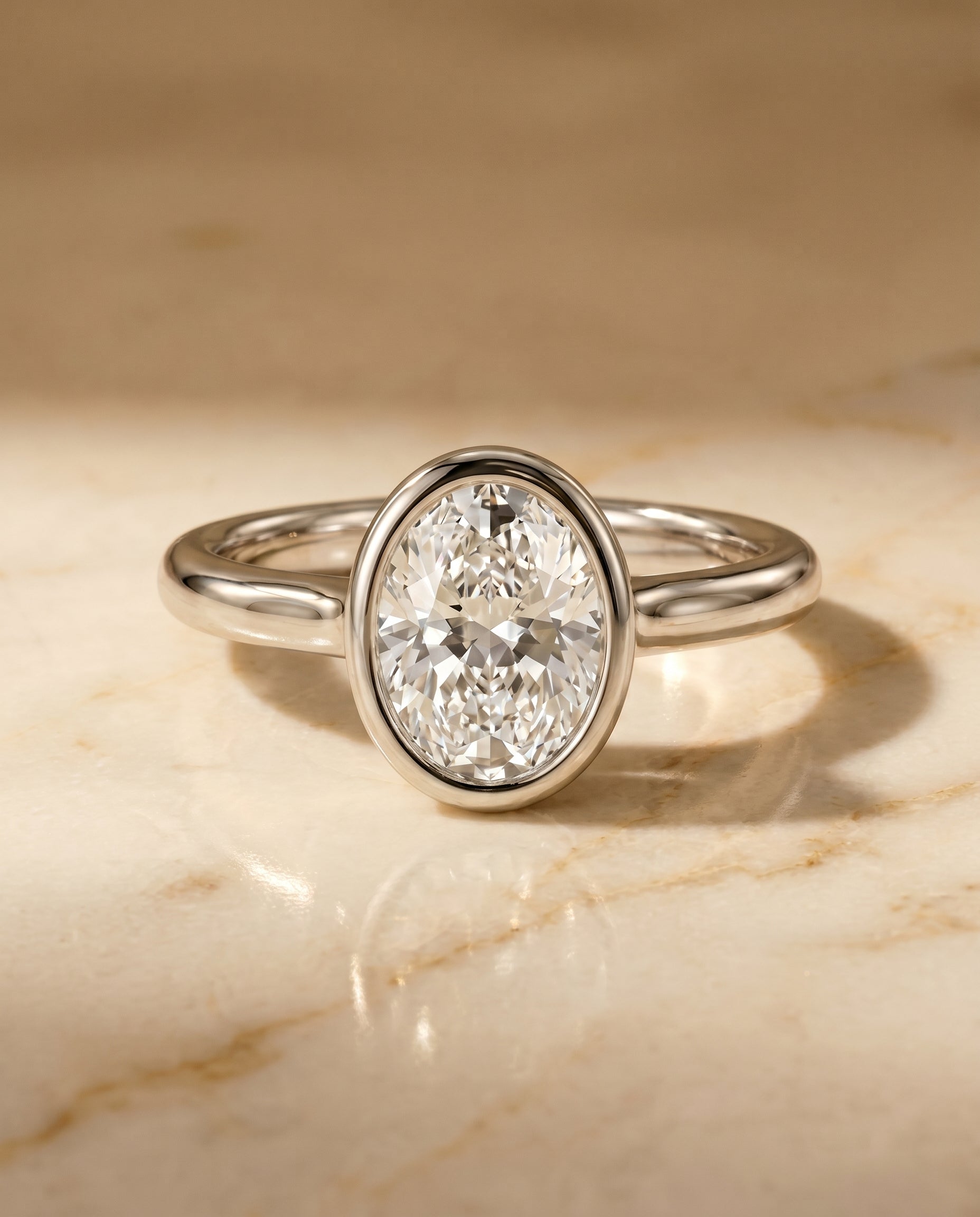 Agnes Select Bezel Solitaire In Oval Lab Diamond Engagement Ring in Platinum, shown on hand, angled | RockHer