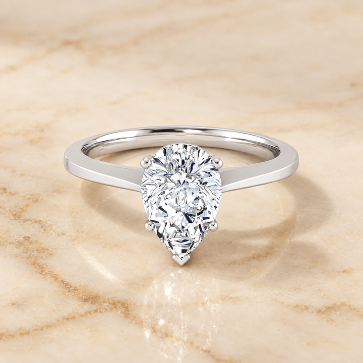 The Elena Timeless Graduated Beveled Shank Solitaire Pear Engagement Ring Setting in Platinum