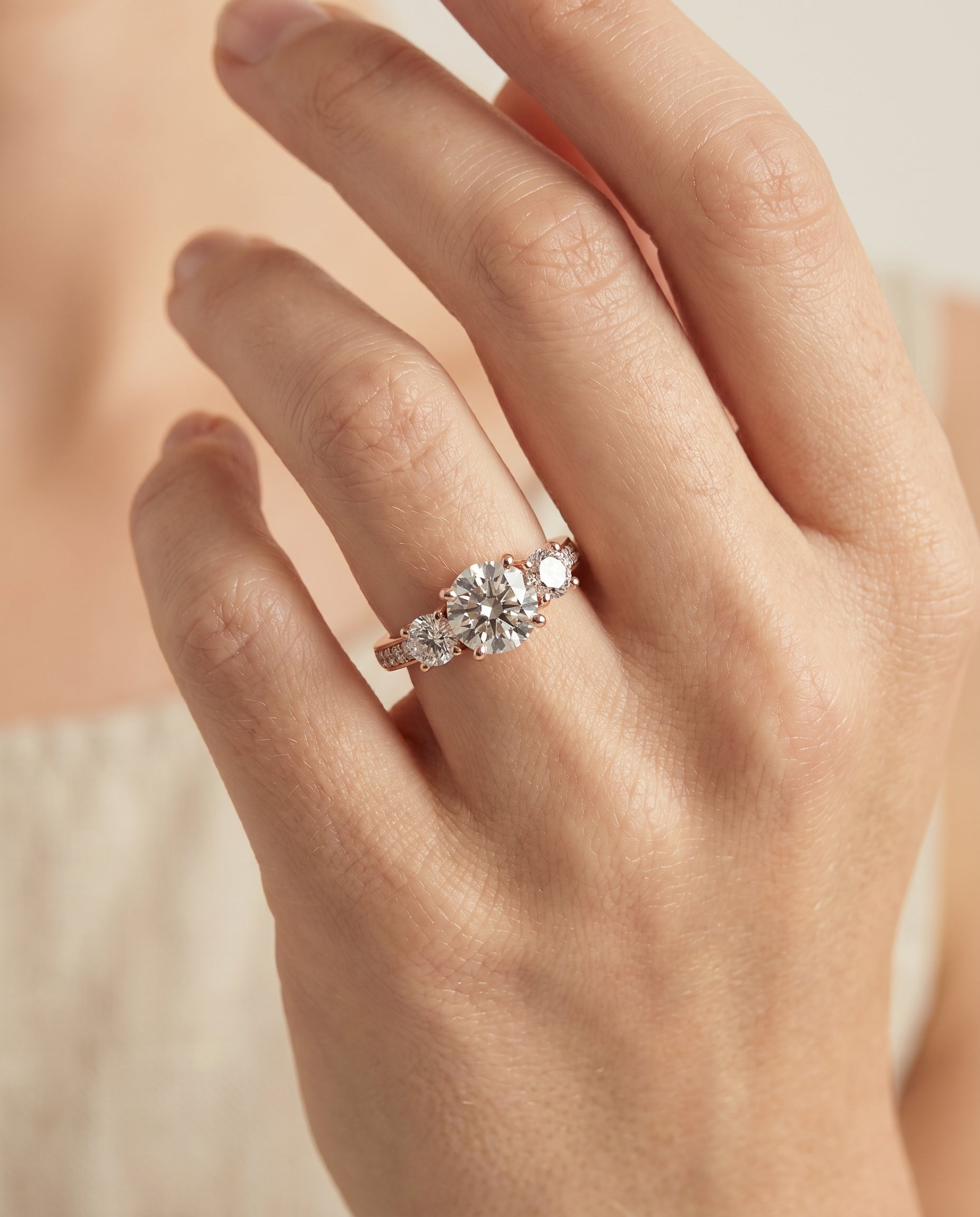 Avery Select Channel Pavé Three Stone Round Lab Diamond Engagement Ring in 14K Rose Gold, shown on hand | RockHer