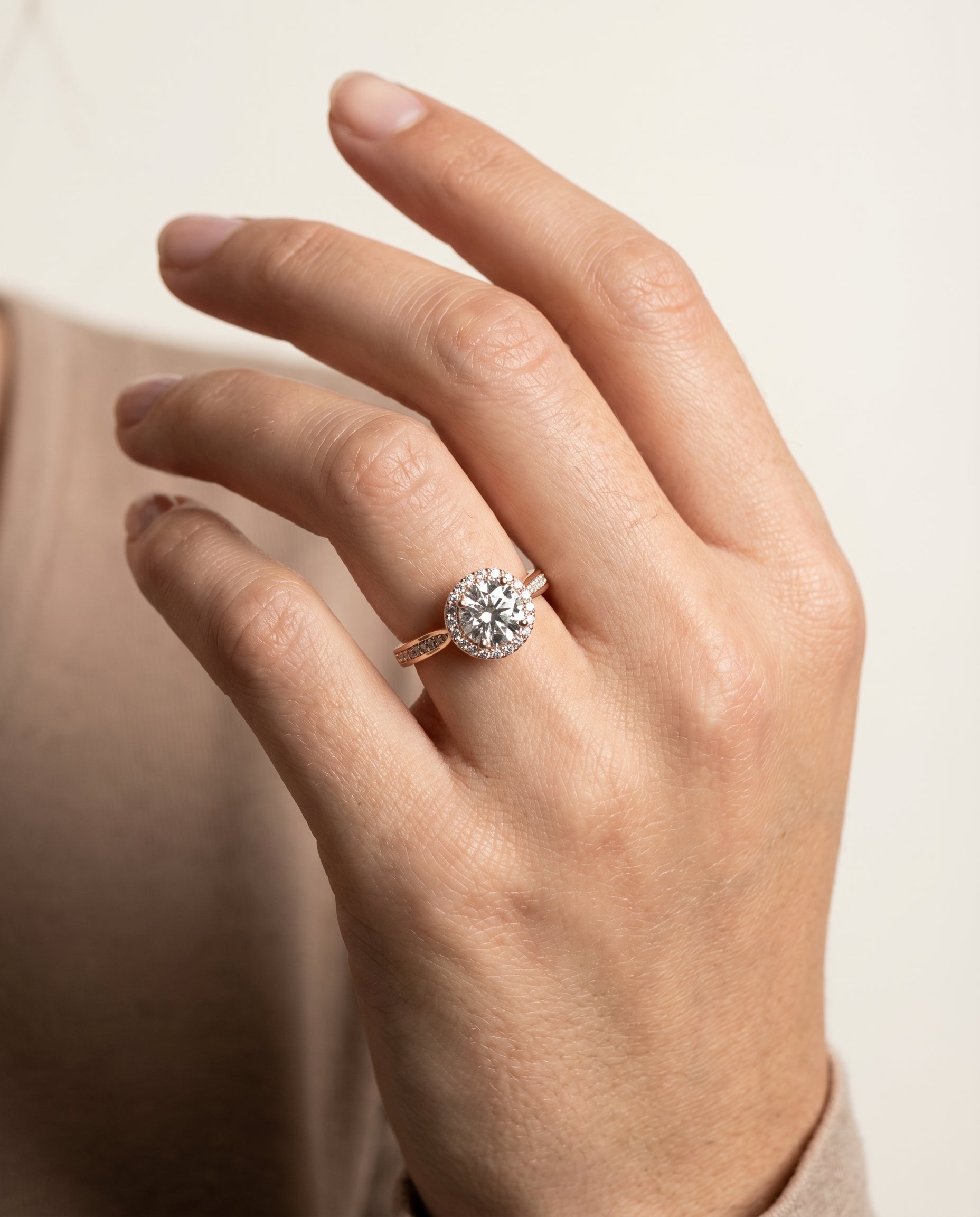 Aria Select Channel Row Pavé Halo Round Lab Diamond Engagement Ring in 14K Rose Gold, shown on hand | RockHer