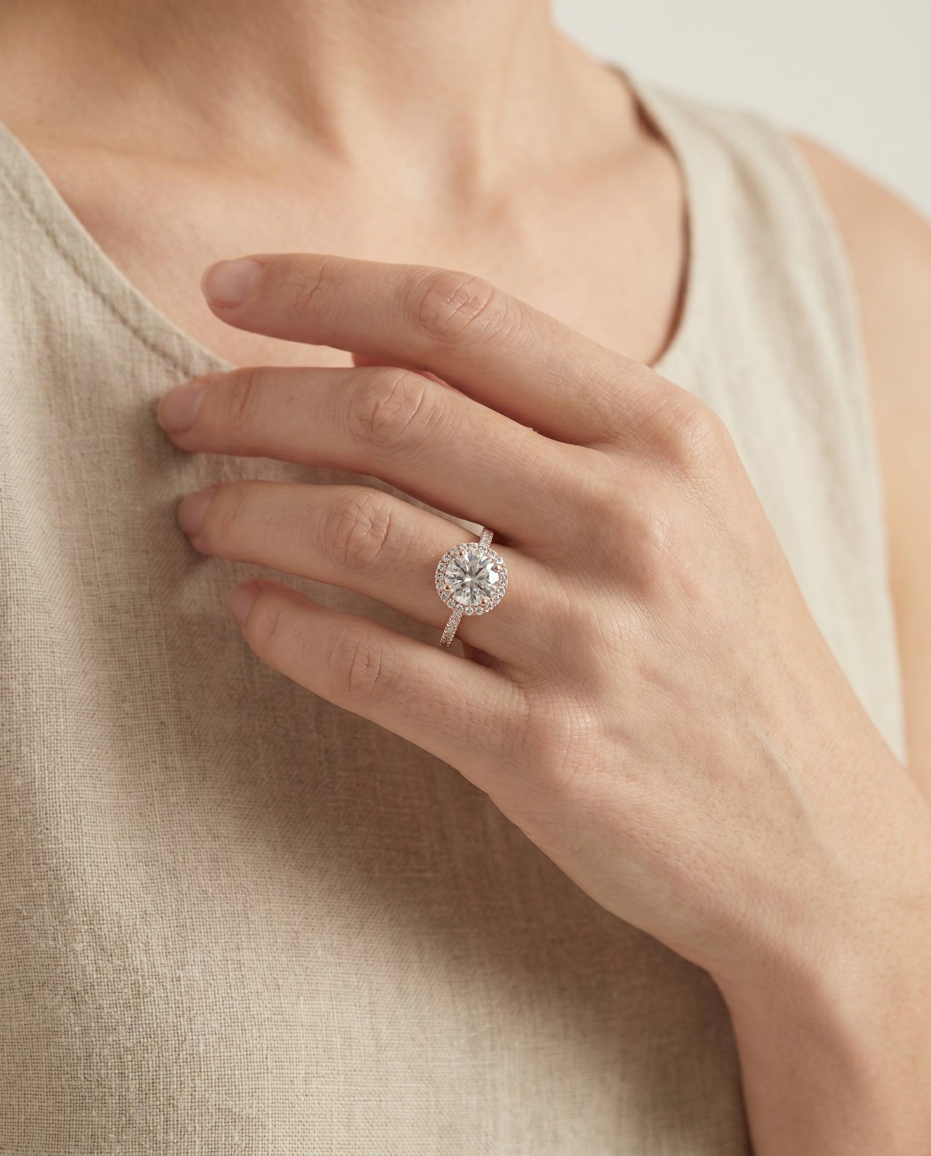 Taylor Select Pavé Halo Round Lab Diamond Engagement Ring in 14K Rose Gold, shown on hand, angled | RockHer