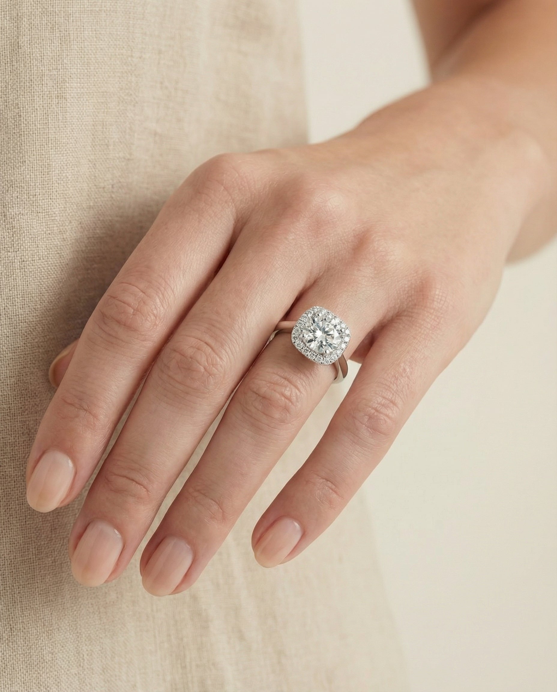 Carnie Select Classic Prong Diamond Halo Round Lab Diamond Engagement Ring in Platinum, shown on hand, angled | RockHer