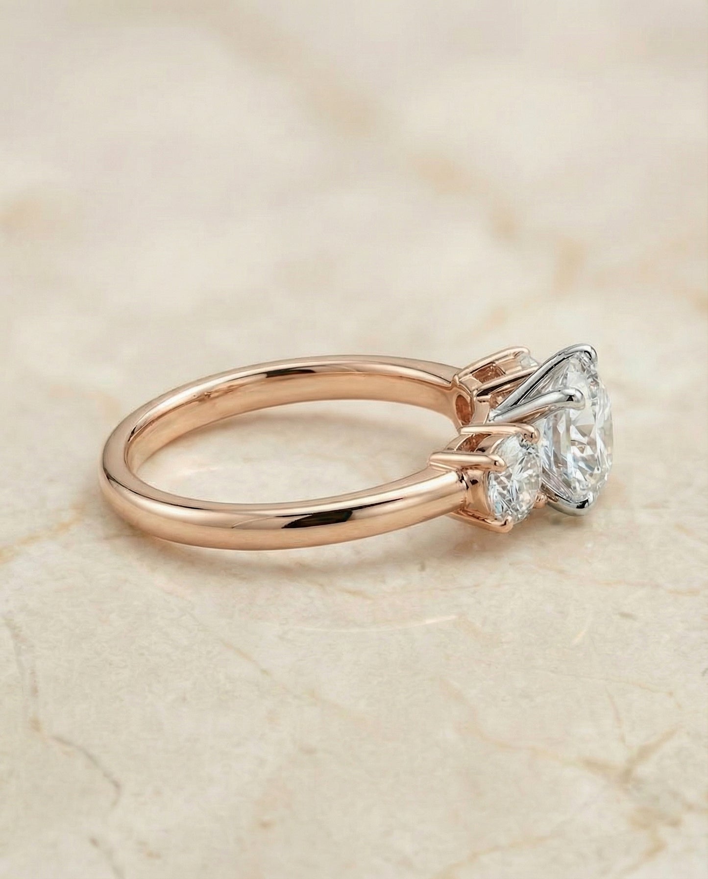 Round Brilliant, Classic Three Stone Round, in 14K Rose Gold, prong setting – side profile | RockHer