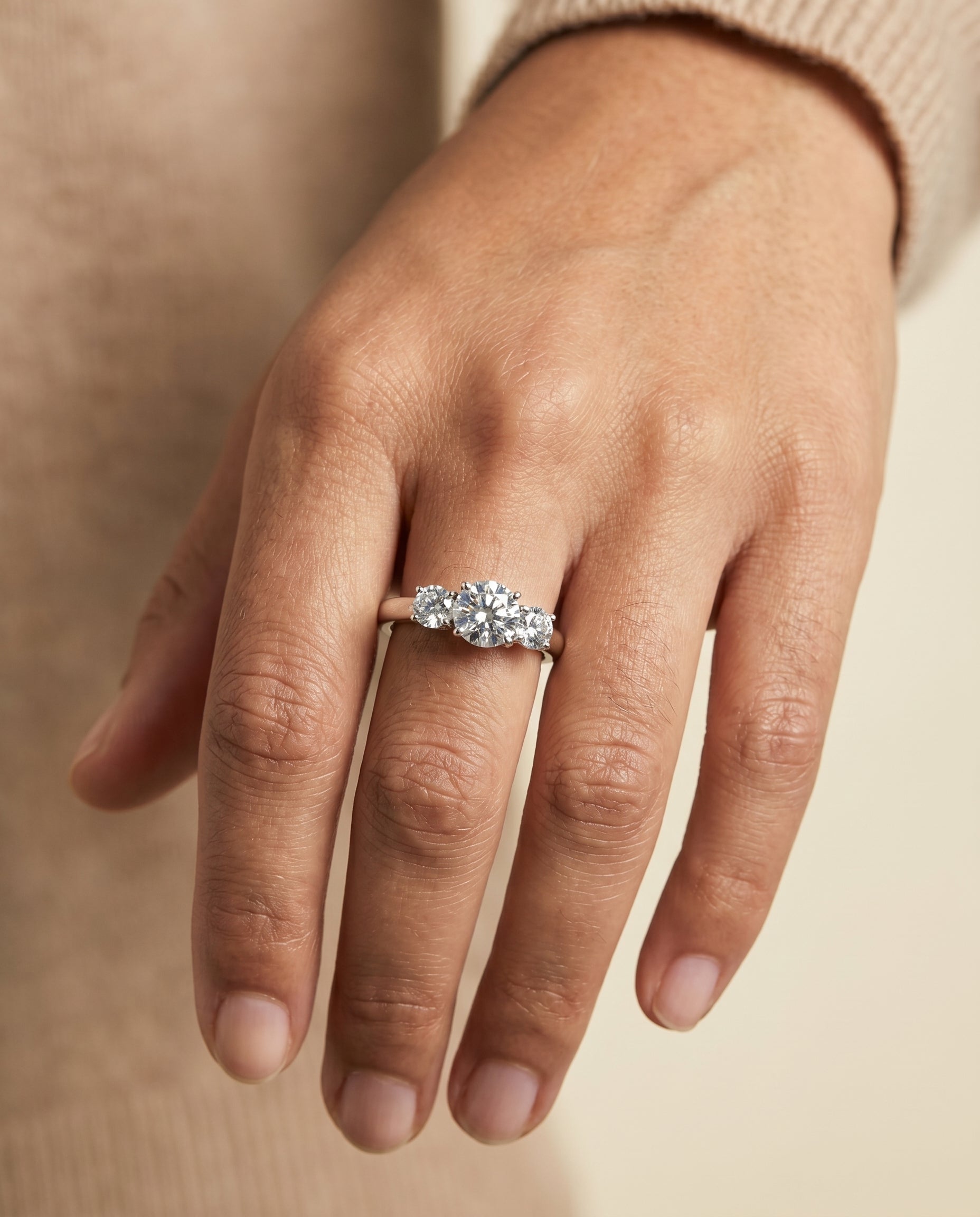Natalie Select Classic Three Stone Round Lab Diamond Engagement Ring in Platinum, shown on hand | RockHer