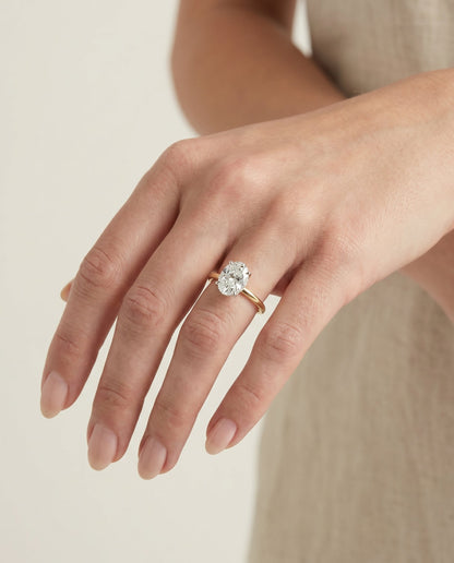 Cyndi Select Curved Hidden Halo Solitaire Oval Lab Diamond Engagement Ring in 14K Yellow Gold, shown on hand, angled | RockHer