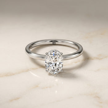 The Cyndi Curved Hidden Halo Solitaire Oval Engagement Ring Setting in 18K White Gold
