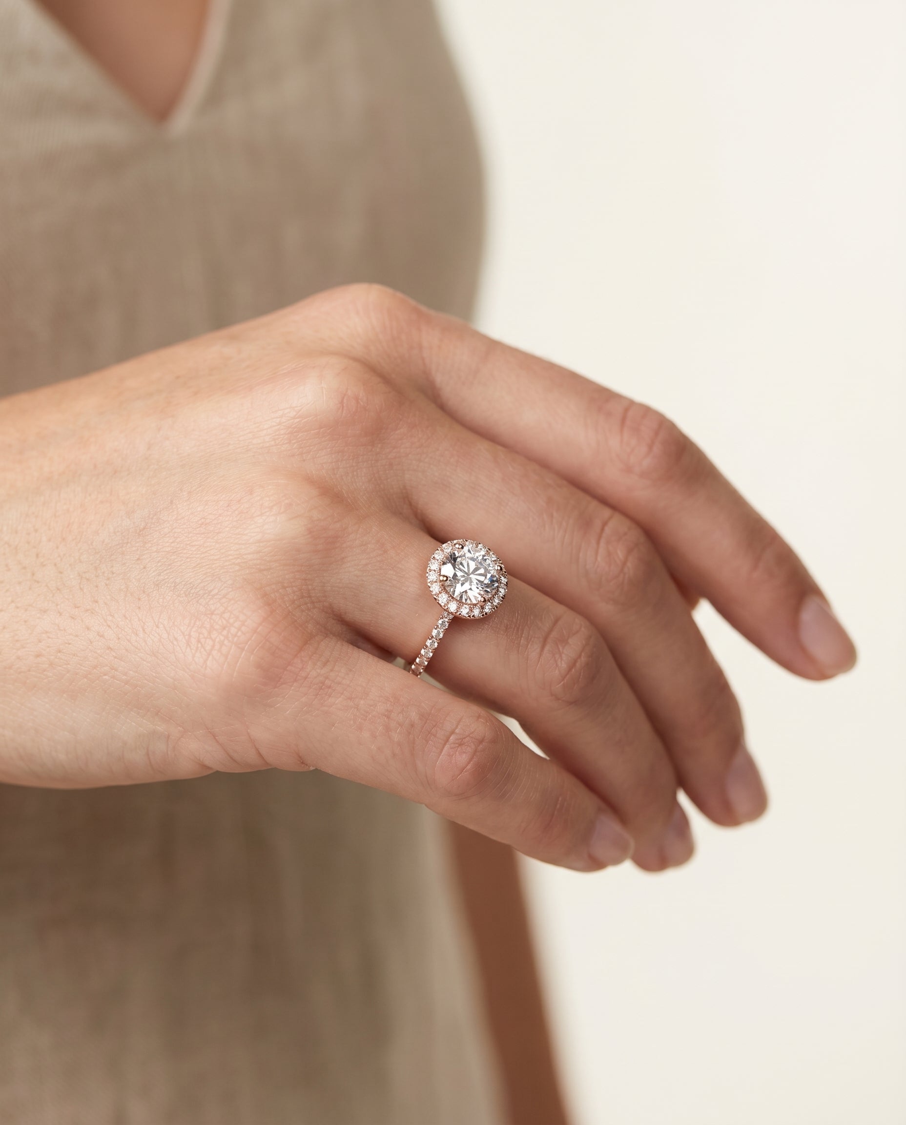 Dionne Select Diamond Pavé Halo Round Lab Diamond Engagement Ring in 14K Rose Gold, shown on hand, angled | RockHer
