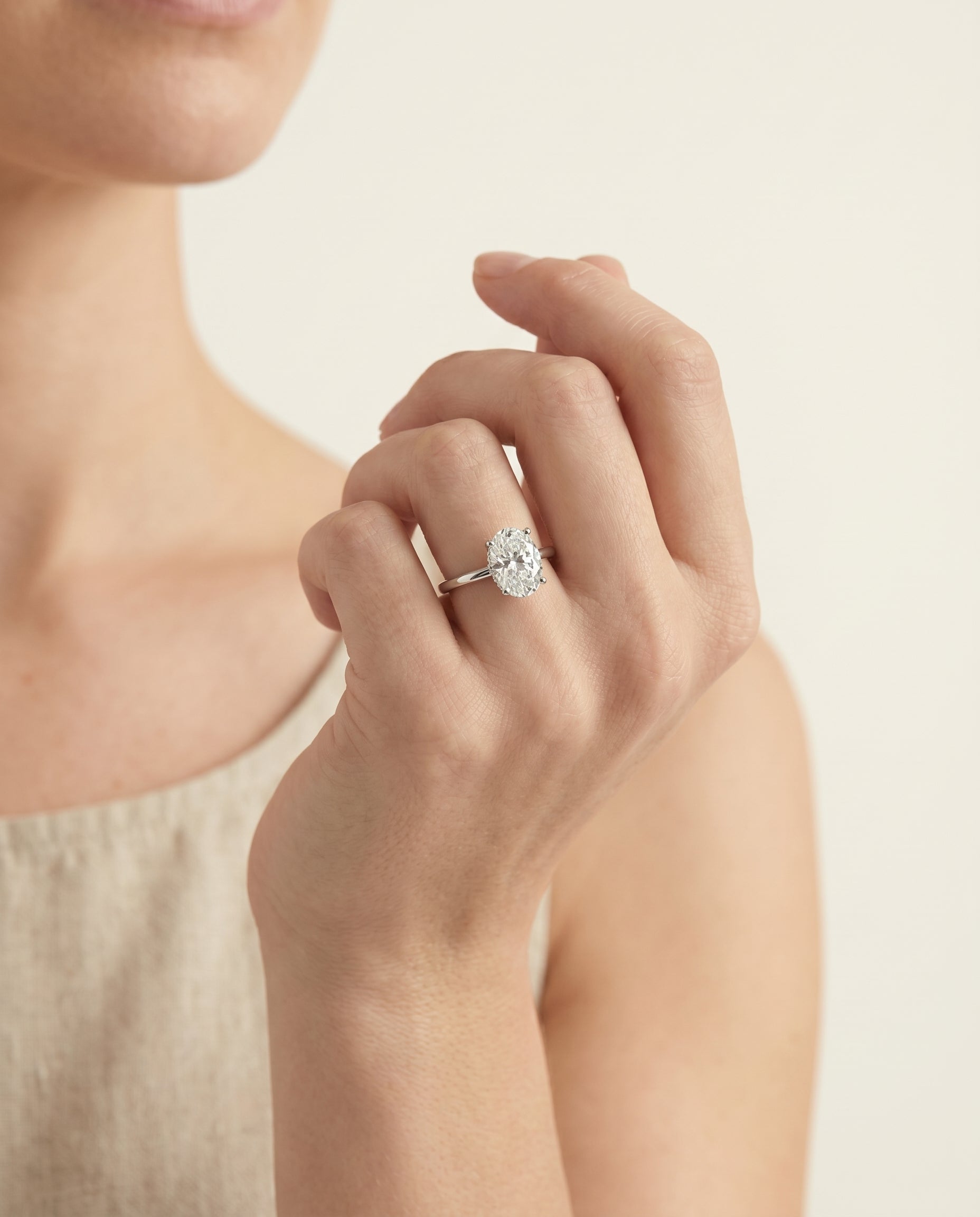 Dolly Select Double Hidden Halo Solitaire Oval Lab Diamond Engagement Ring in 18K White Gold, shown on hand, angled | RockHer