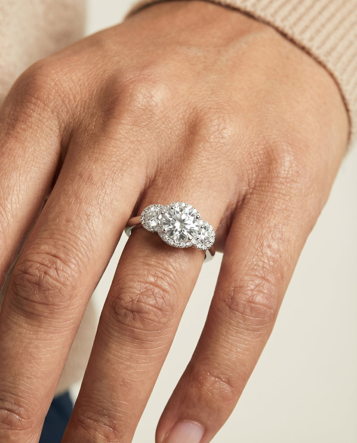 Anna Select Three Stone Halo Round Lab Diamond Engagement Ring in 18K White Gold, shown on hand, angled | RockHer