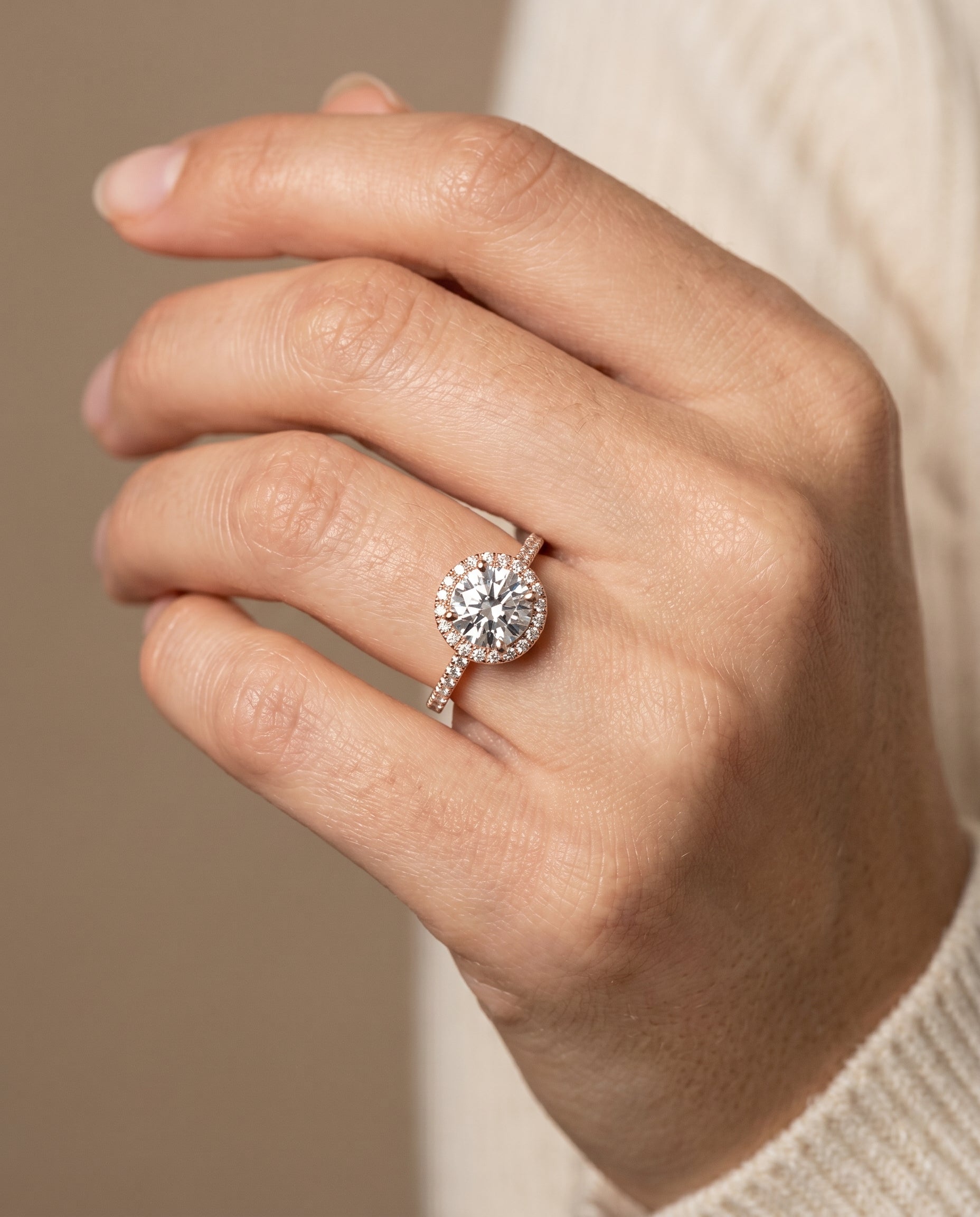 Sonata Select Graduated Shank Pavé Halo Round Lab Diamond Engagement Ring in 14K Rose Gold, shown on hand | RockHer