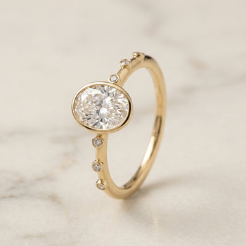 The Brandi Bezel Accent Solitaire Engagement Ring Setting for Oval Diamonds in 18K Yellow Gold