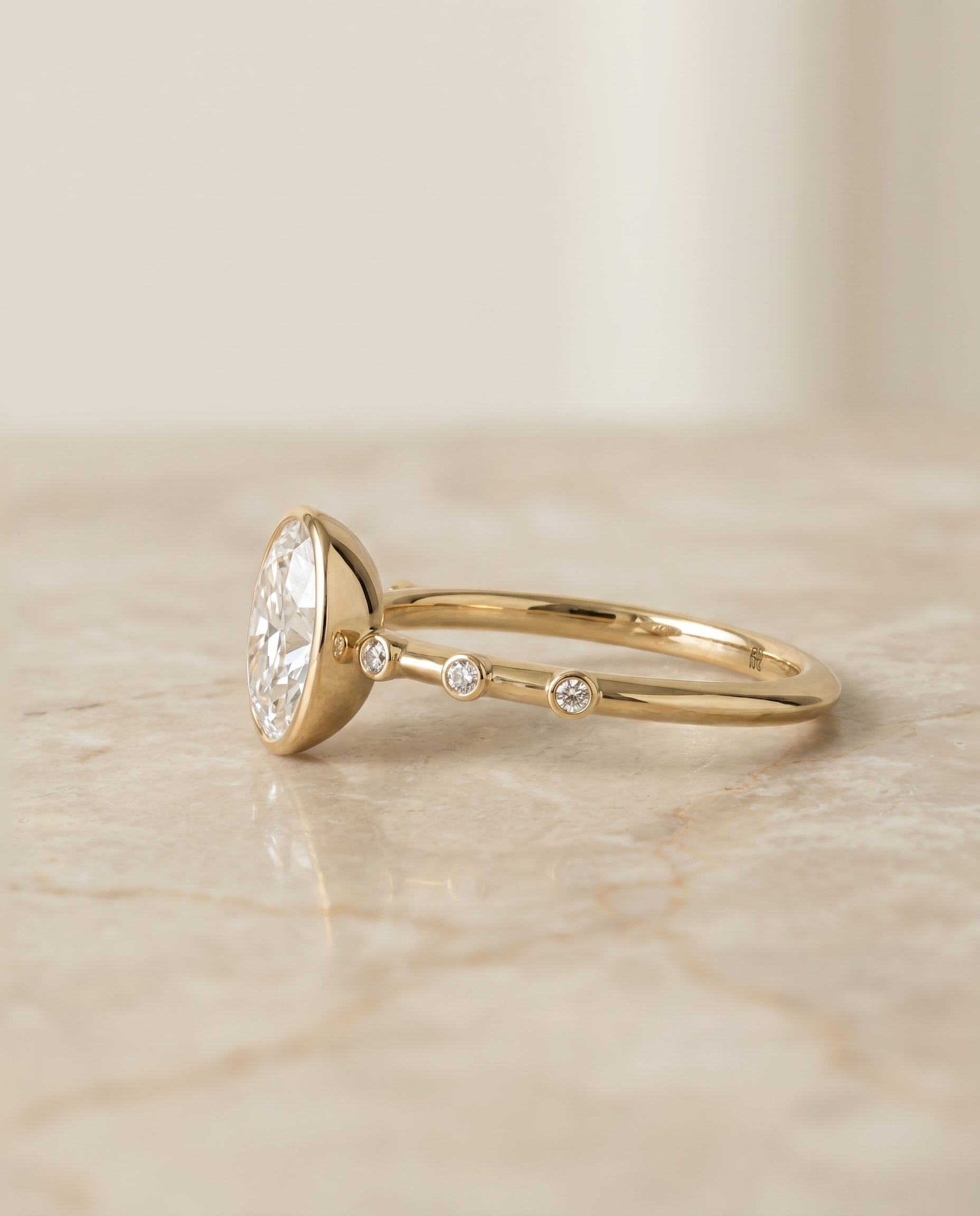 Bezel Accent Solitaire Engagement Ring Setting for Oval Diamonds in 18K Yellow Gold styling on The Brandi diamond engageme...