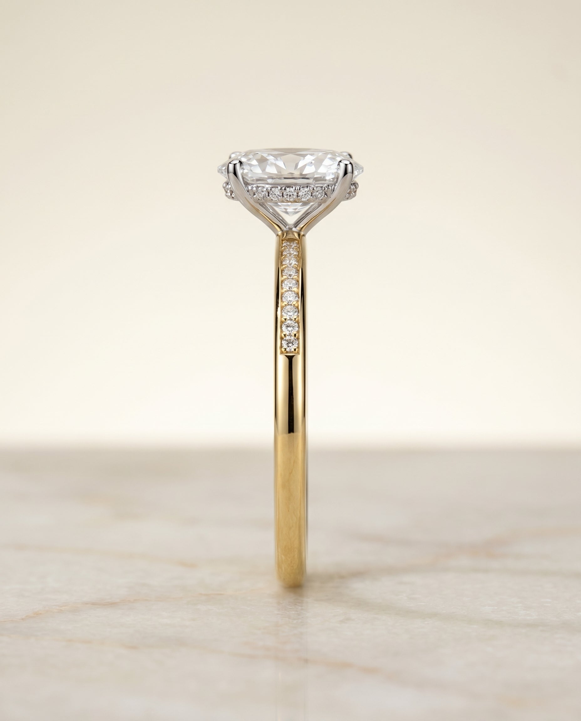 The Brenda hidden halo engagement ring setting for oval diamonds in 18k yellow gold engagement ring setting, shown in prec...