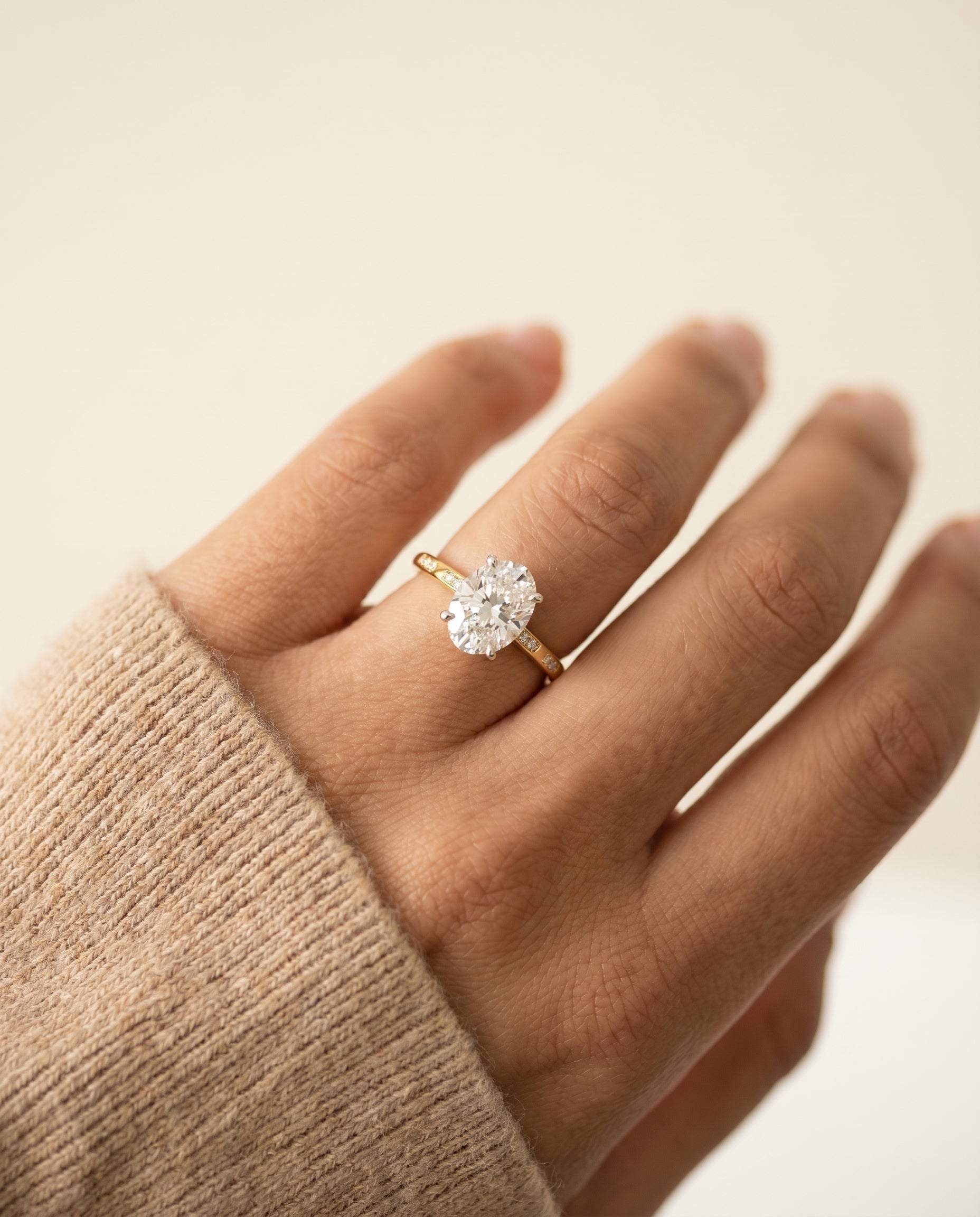 Wanda Select Hidden Halo Pavé Solitaire Oval Lab Diamond Engagement Ring in 18K Yellow Gold, shown on hand, angled | RockHer