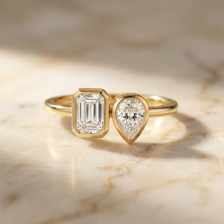 18K Yellow Gold Josephine Select Toi et Moi Emerald & Pear Bezel Set Lab Diamond Engagement Ring - Hero on warm marble