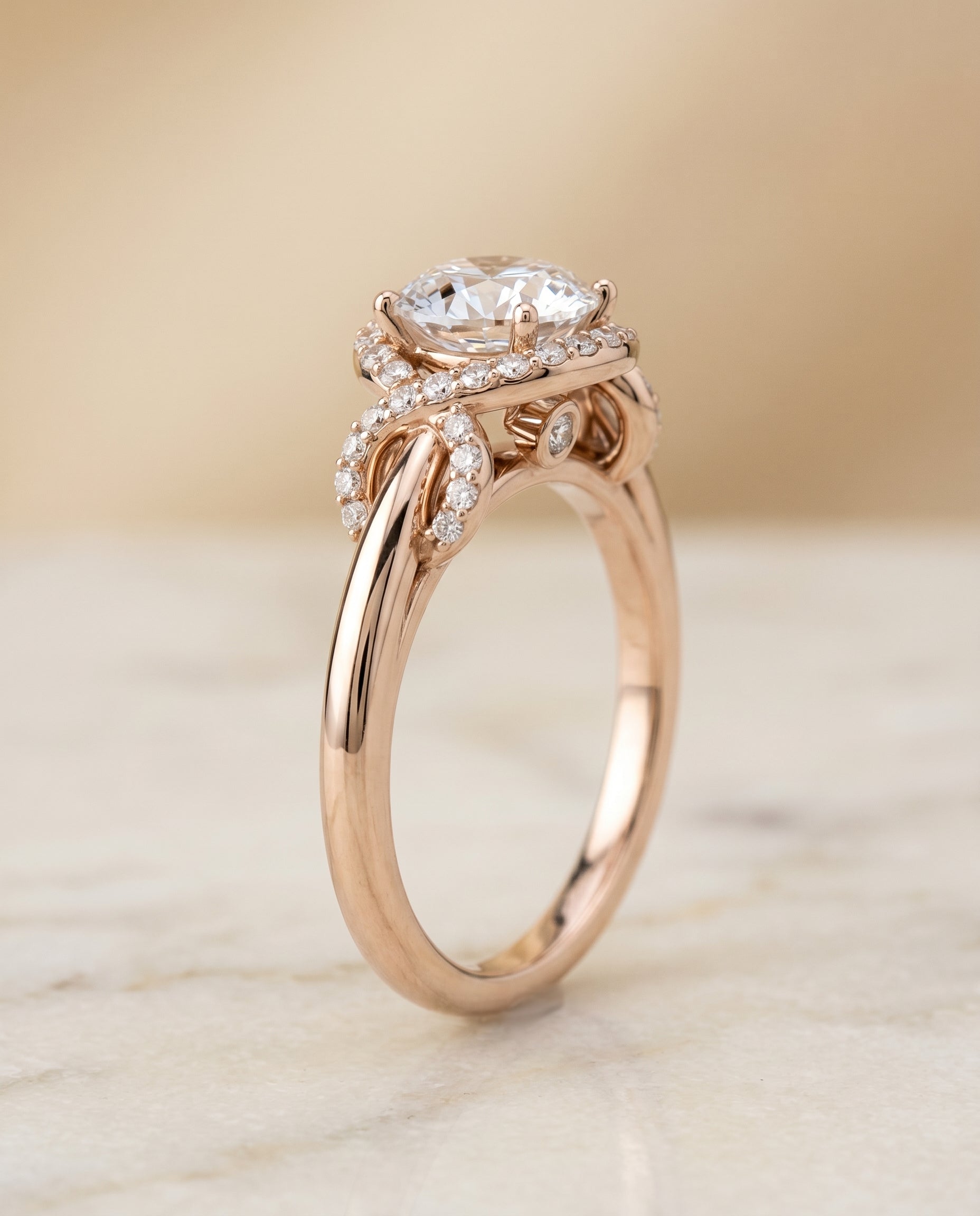 Calista Select Love Knot Halo Round Lab Diamond Engagement Ring in 14K Rose Gold, front view | RockHer