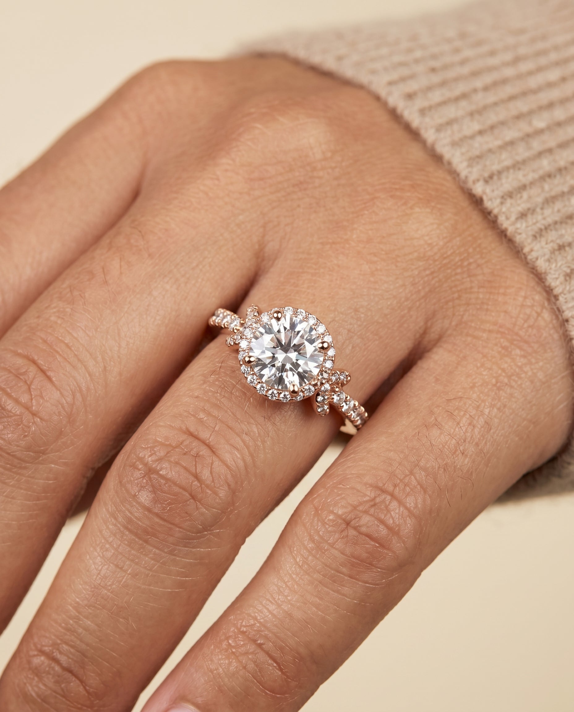 Bess Select Love Knot Pavé Halo Round Lab Diamond Engagement Ring in 14K Rose Gold, shown on hand, angled | RockHer