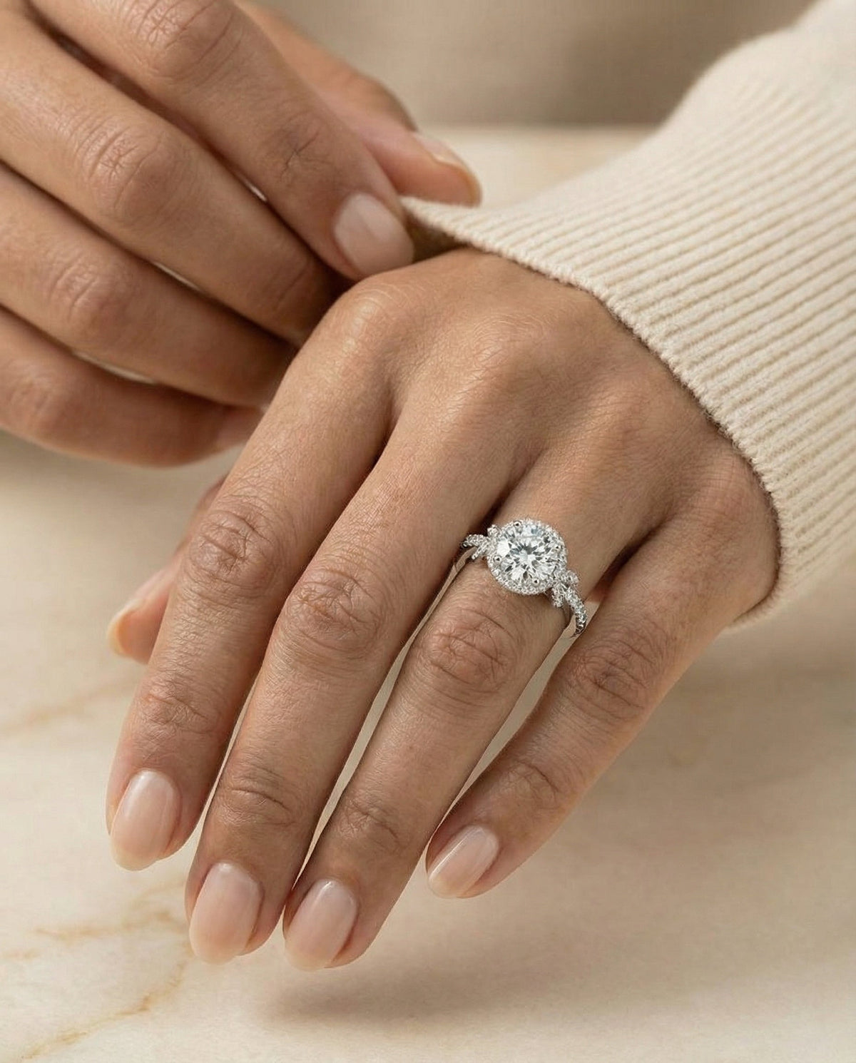 Bess Select Love Knot Pavé Halo Round Lab Diamond Engagement Ring in Platinum, shown on hand, angled | RockHer