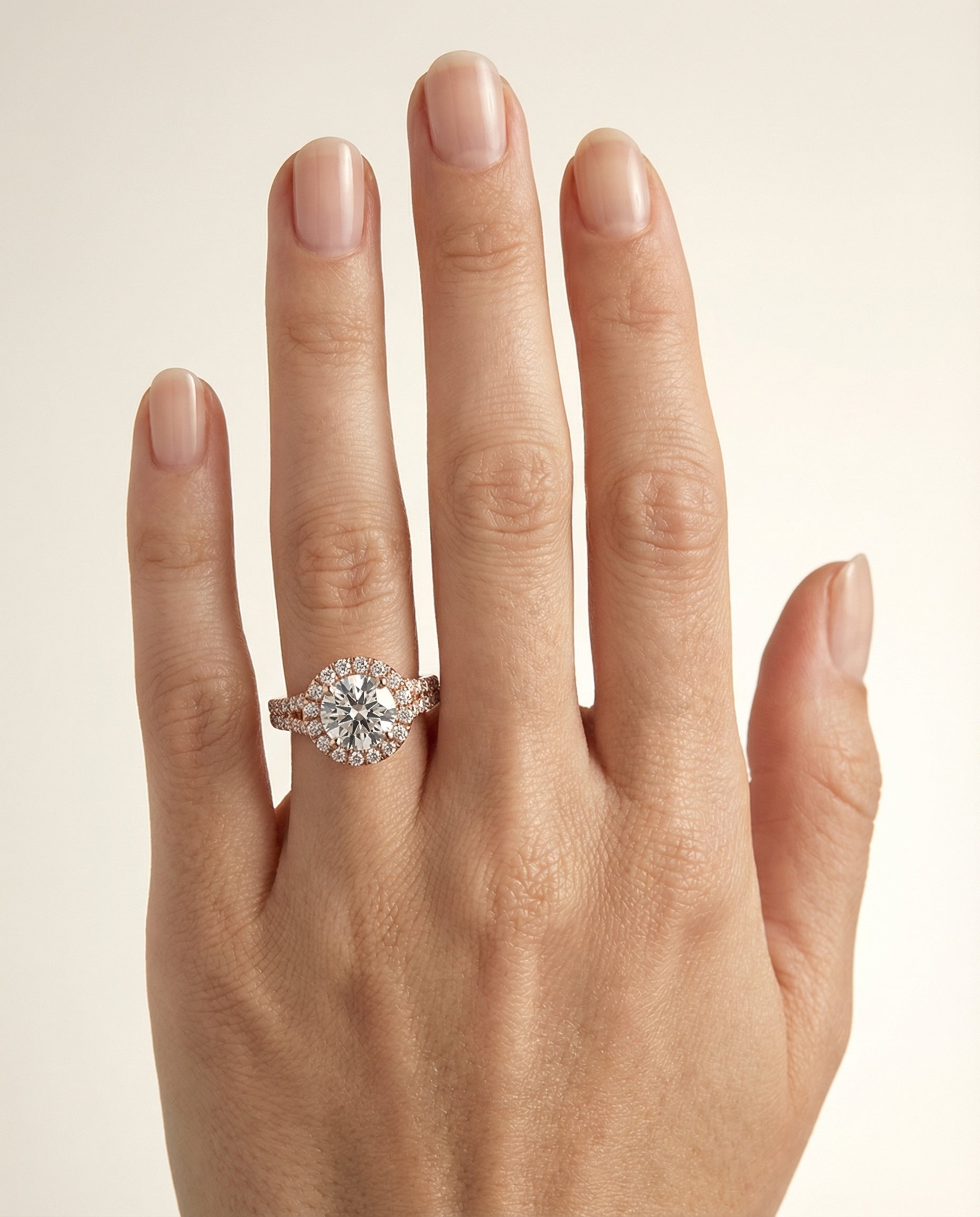Calliope Select Petite Split Shank Halo Round Lab Diamond Engagement Ring in 14K Rose Gold, shown on hand | RockHer