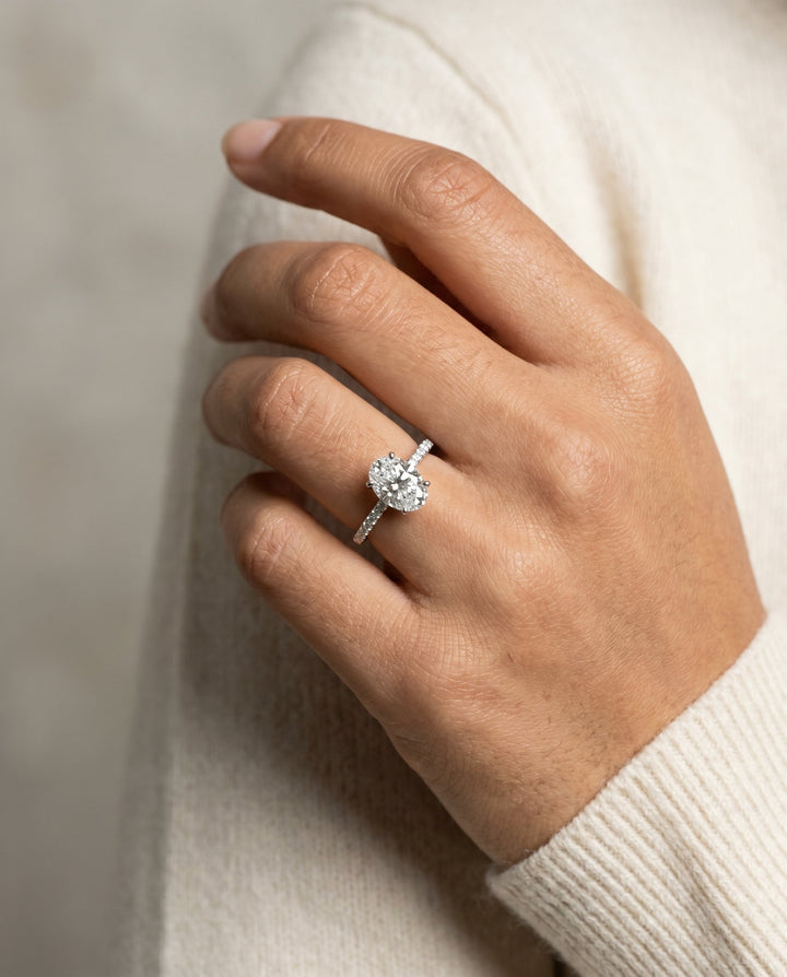 Cherie Select Hidden Halo Pavé Solitaire Oval Lab Diamond Engagement Ring in Platinum, shown on hand, angled | RockHer