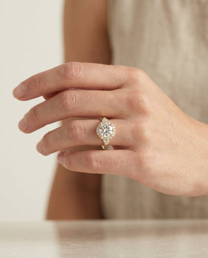 Kai Select Scroll Gallery Halo Round Lab Diamond Engagement Ring in 18K Yellow Gold, shown on hand, angled | RockHer