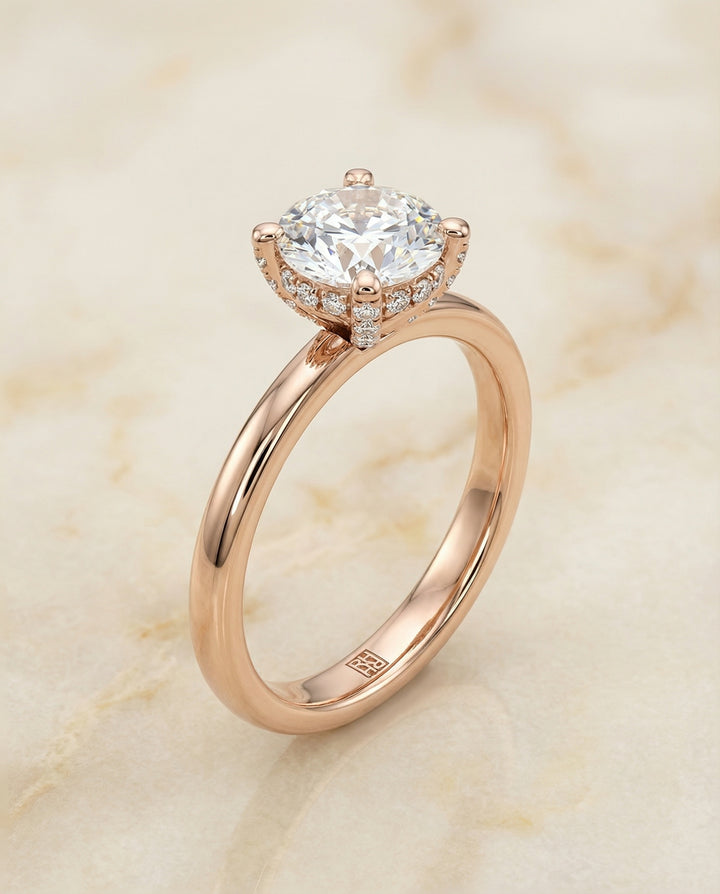 Round Brilliant, Secret Halo Adorned Prong Solitaire, in 14K Rose Gold – angled view | RockHer