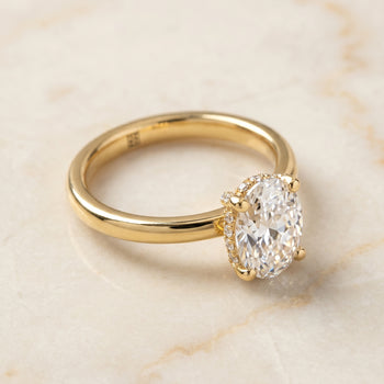 The Lana Secret Halo Adorned Prong Solitaire Oval Engagement Ring Setting in 18K Yellow Gold