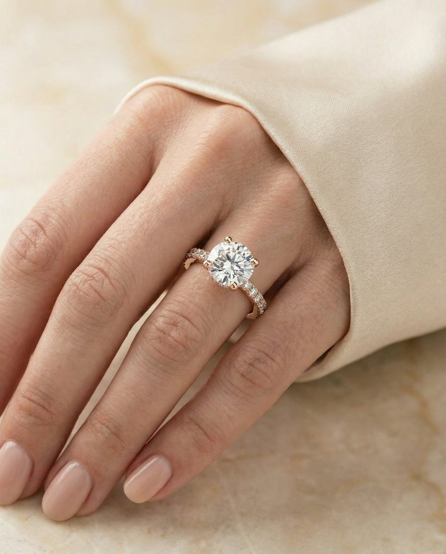 Elliott Select Hidden Halo Pavé Round Lab Diamond Engagement Ring in 14K Rose Gold, shown on hand, angled | RockHer
