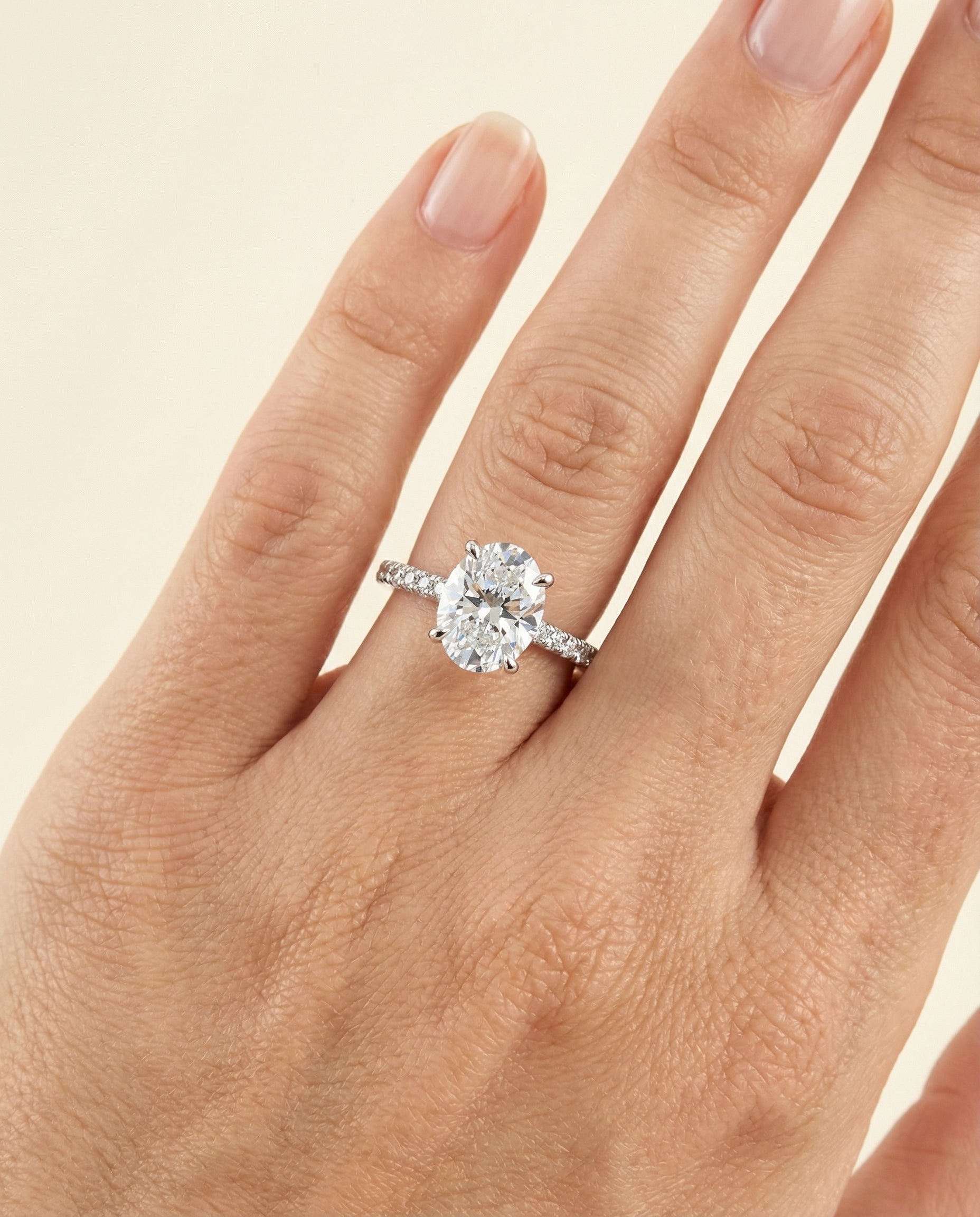 Elliott Select Hidden Halo Pavé Oval Lab Diamond Engagement Ring in Platinum, shown on hand, angled | RockHer