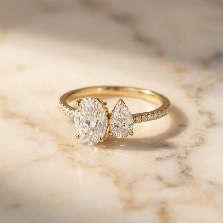 18K Yellow Gold Selena Select Toi et Moi Oval & Pear Pavé Band Lab Diamond Engagement Ring - Hero on warm marble
