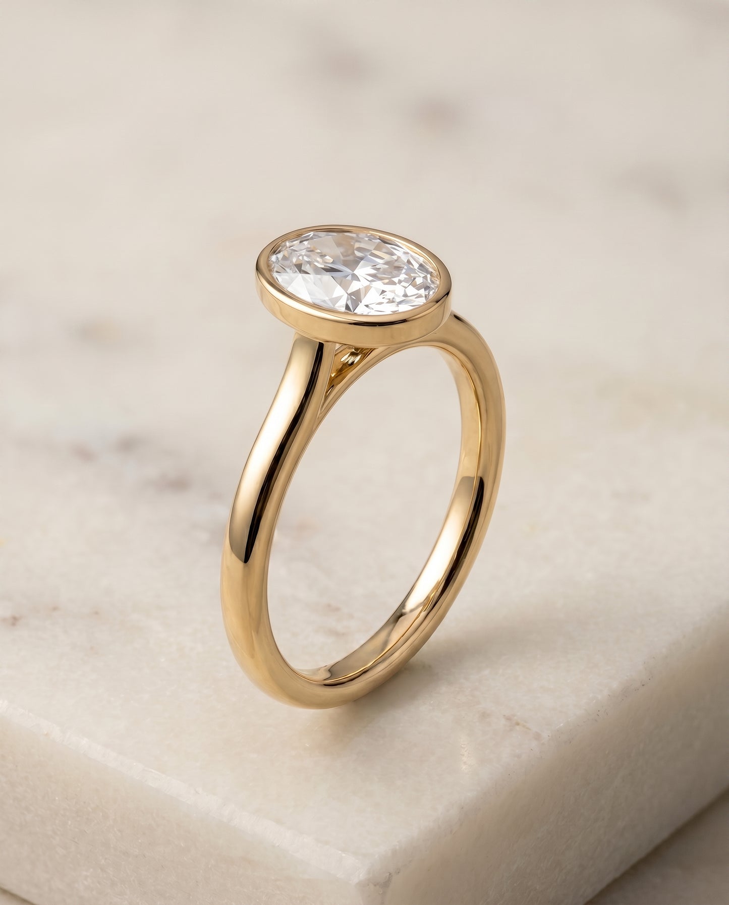 The Duran Simple Bezel Solitaire Engagement Ring Setting for Oval Diamonds in 18K Yellow Gold
