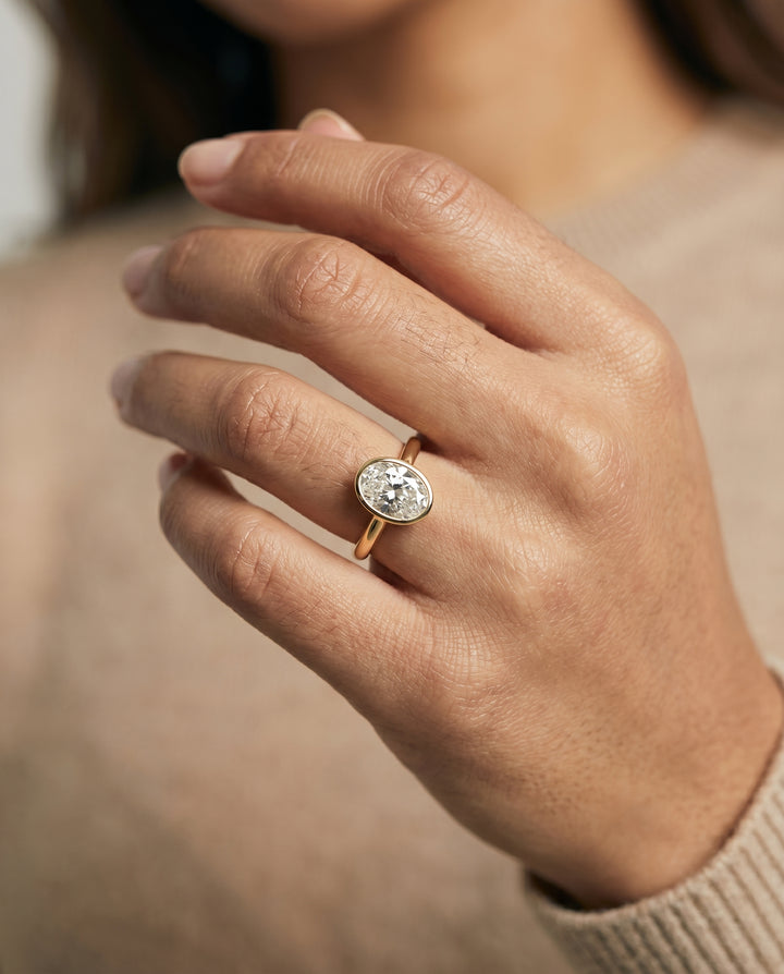 The Duran Simple Bezel Solitaire Engagement Ring Setting for Oval Diamonds in 18K Yellow Gold