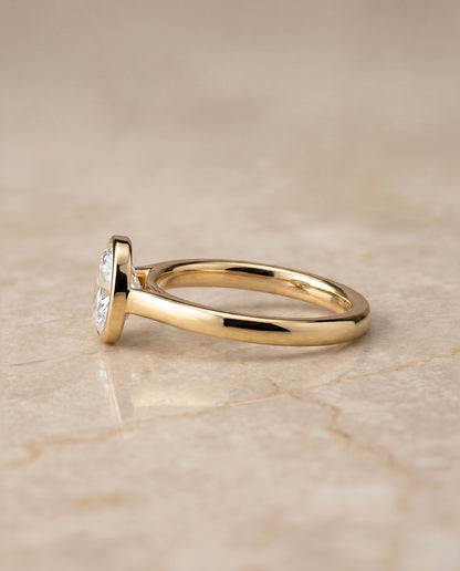 The Duran Simple Bezel Solitaire Oval Engagement Ring Setting in 18K Yellow Gold