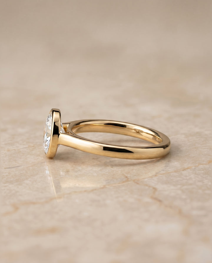The Duran Simple Bezel Solitaire Engagement Ring Setting for Oval Diamonds in 18K Yellow Gold