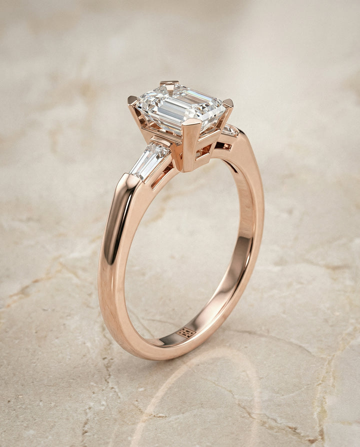 European Cut, Tapered Baguette Three Stone Emerald, in 14K Rose Gold, prong setting – front view | RockHer