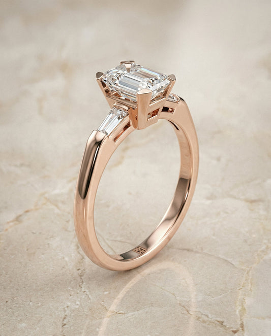 Caroline Select tapered baguette three stone emerald cut emerald cut ring in 14K Rose Gold — front — RockHer
