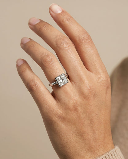 Agnes Select Bezel Solitaire In Princess Cut Lab Diamond Engagement Ring in Platinum, shown on hand | RockHer