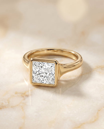 Agnes Select Bezel Solitaire In Princess Cut Lab Diamond Engagement Ring in 18K Yellow Gold, shown on hand, angled | RockHer